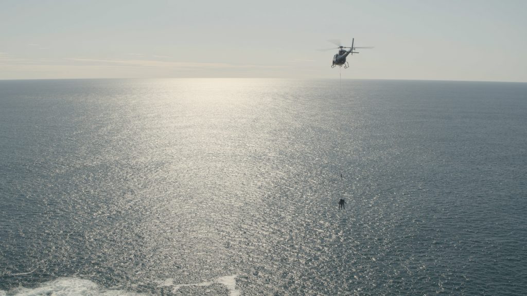 Still image of helicopter performing an aerial stunt called Human External Cargo for Ultimate Hell Week. 