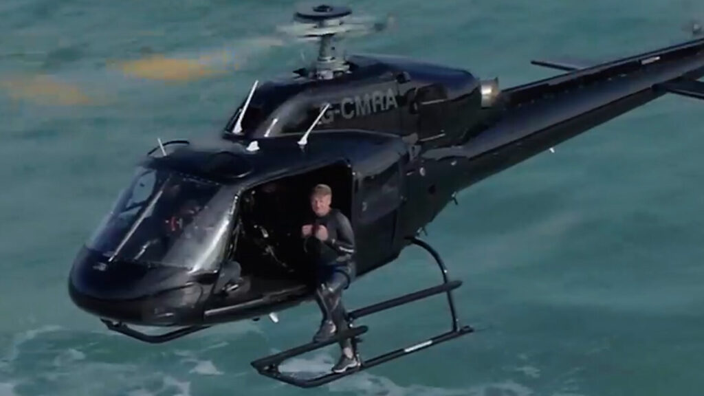Gordon Ramsay sitting on the edge of a helicopter